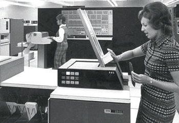 Woman feeds punch cards into machine Woman feeds punch cards into machine